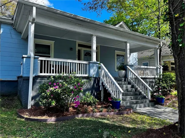 Covered front porch with white railings and columns