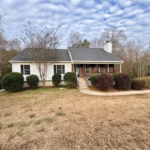 Ranch-style home featuring a porch, a front lawn, and brick siding