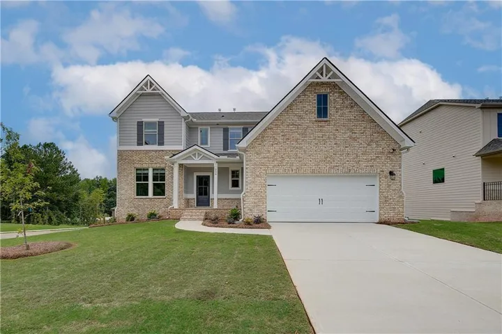 Stately home featuring a light brick facade and gray siding accents