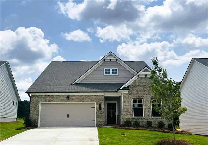 Contemporary exterior featuring a light brick facade, grey horizontal siding, and a dark asphalt shingle roof