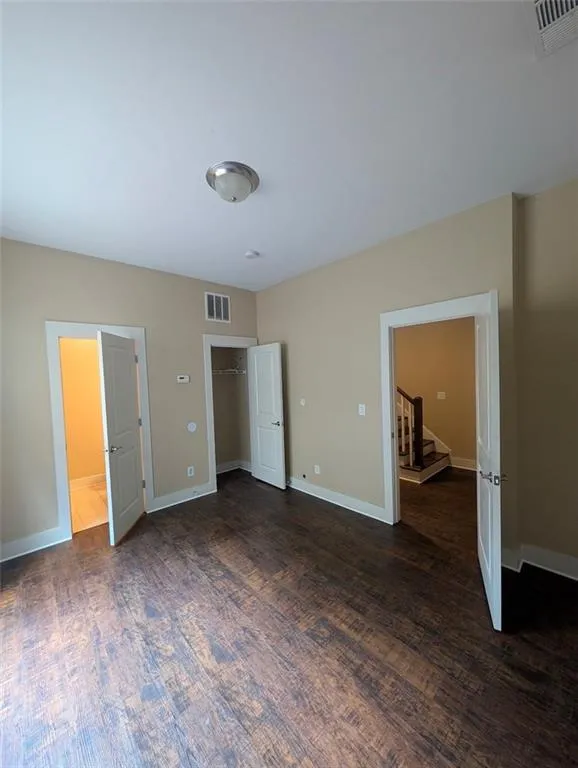 Basement bedroom featuring dark wood-style flooring and baseboards