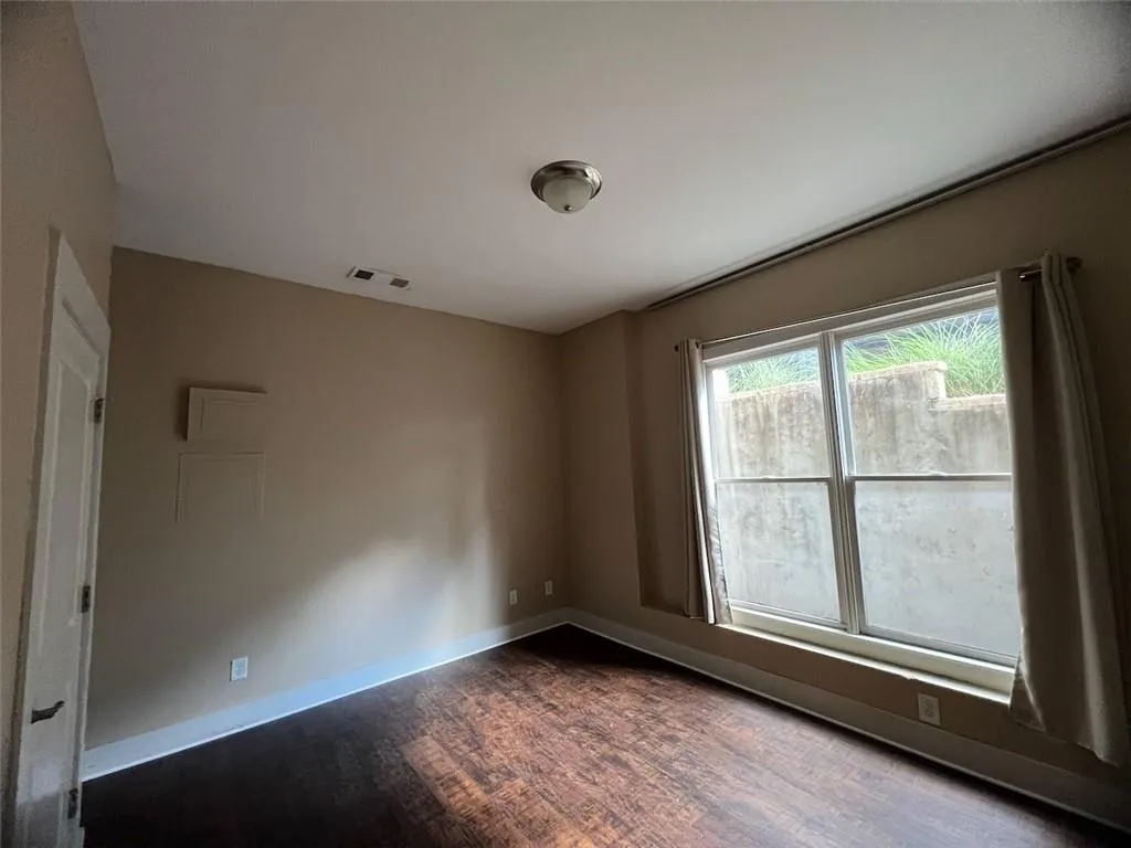 Basement bedroom with dark wood-style flooring and baseboards