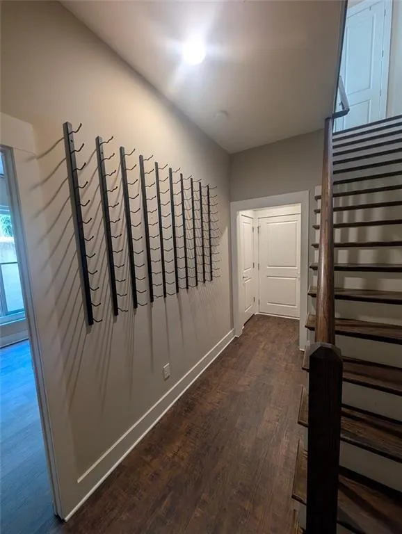 Hall featuring dark wood finished floors and baseboards