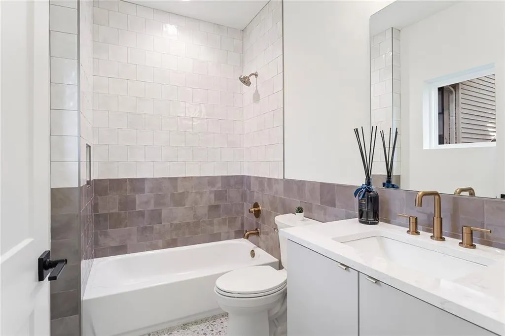 Full bath featuring tub / shower combination, vanity, tile walls, and decorative backsplash