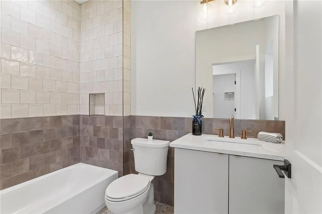 Full bathroom featuring tile walls, vanity, and shower / bath combination
