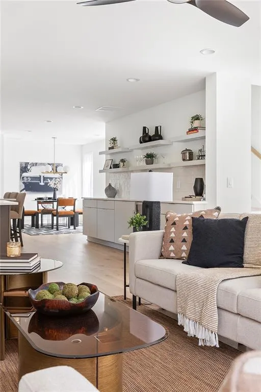 Living area with light wood finished floors and recessed lighting