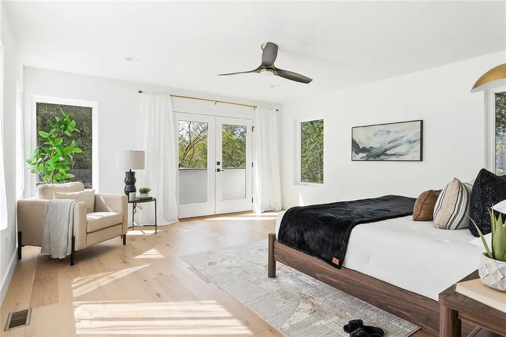 Bedroom with multiple windows, french doors, access to exterior, and light wood finished floors