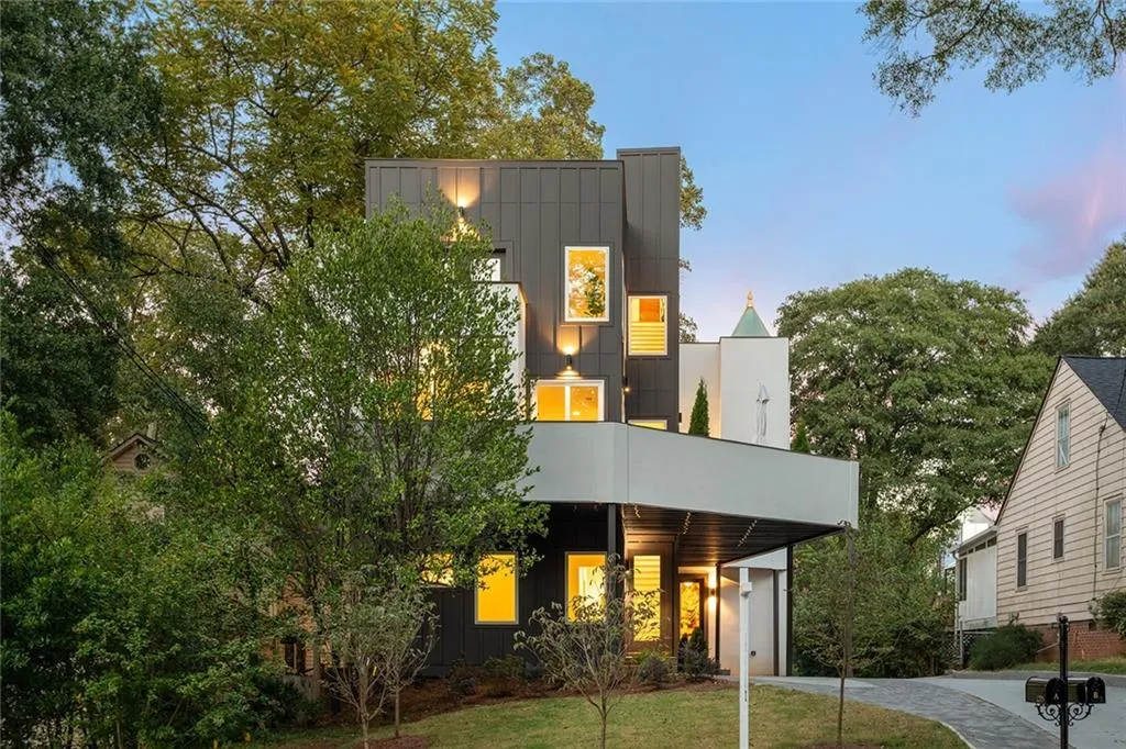 Contemporary house with board and batten siding, a lawn, and a balcony