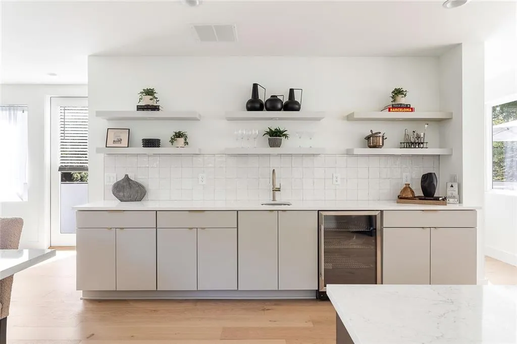 Indoor bar featuring open shelves, modern cabinets, wine cooler, light stone counters, and light wood-style floors