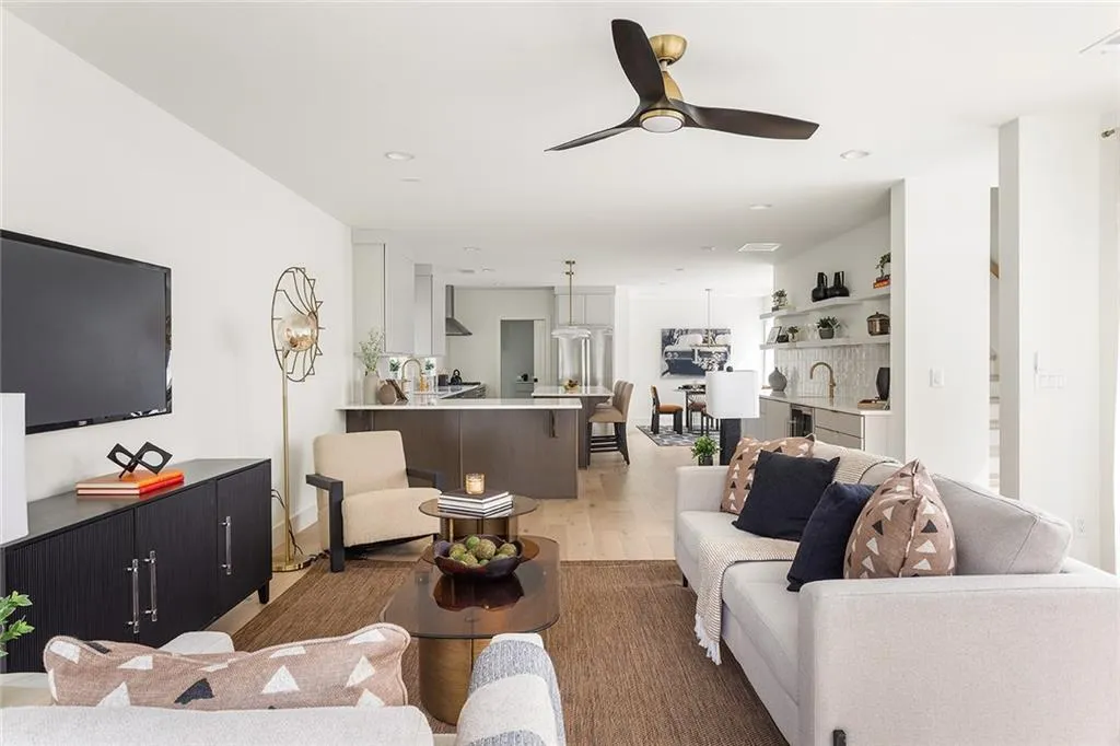 Living area with light wood-style flooring, a ceiling fan, and recessed lighting