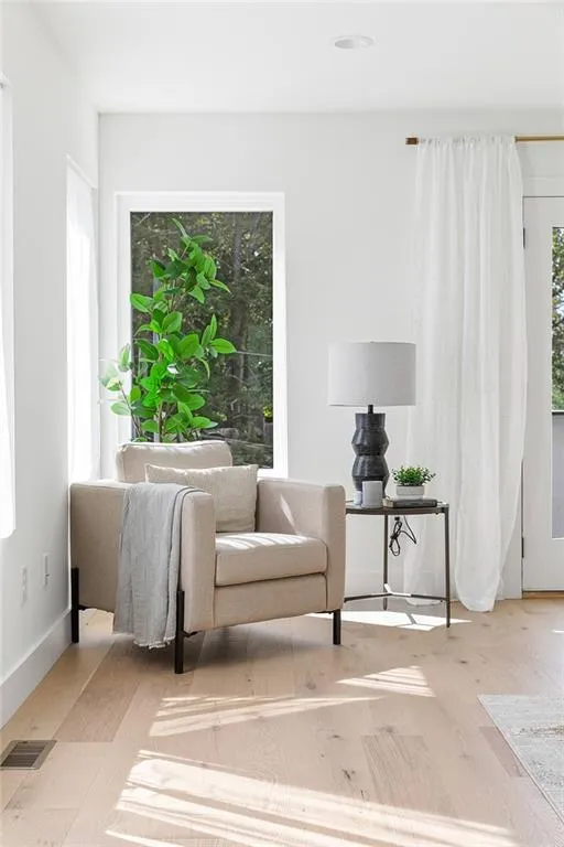 Sitting room with plenty of natural light and light wood finished floors