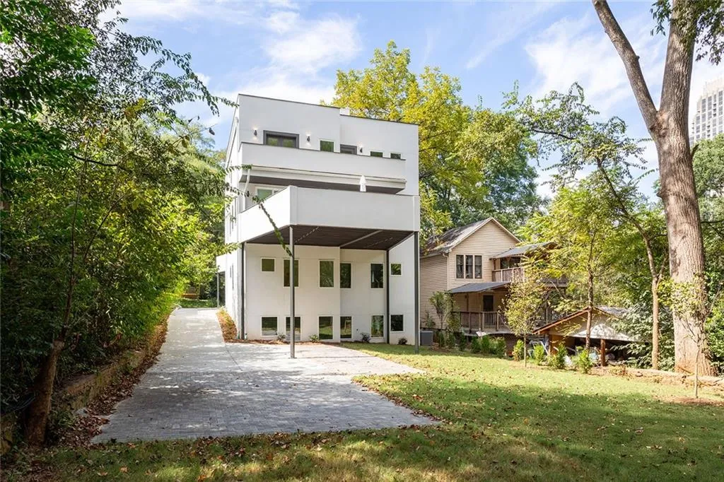 Rear view of property with a balcony, a lawn, and stucco siding