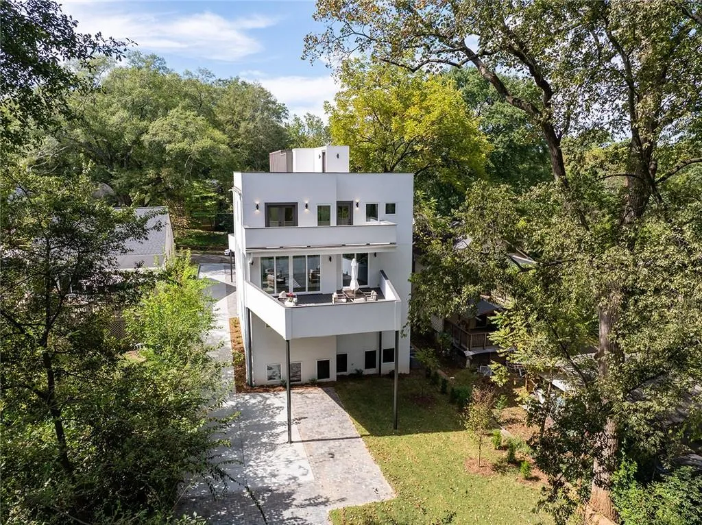 Back of house featuring a lawn, stucco siding, a balcony, and a patio area