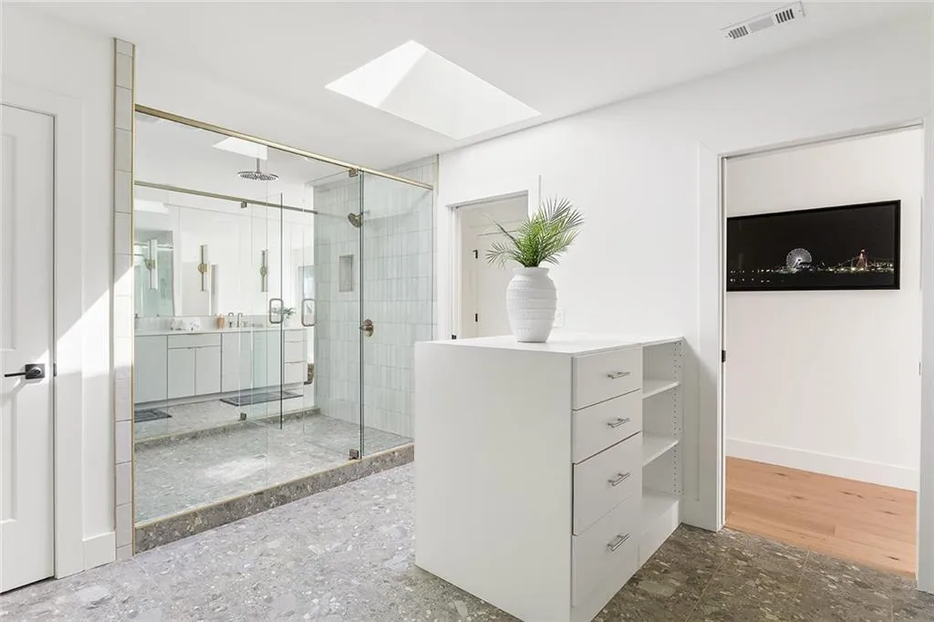 Full bath featuring a shower stall, vanity, and a skylight