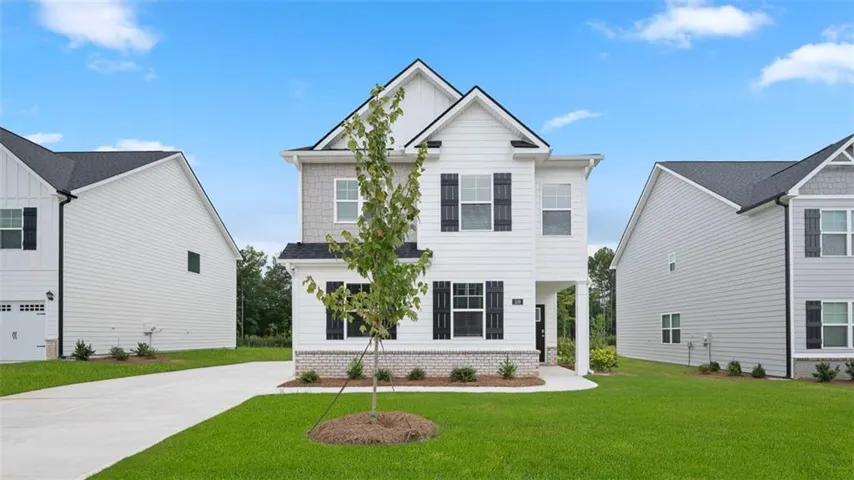 Two-story residence featuring white siding, grey shake accents, and dark window shutters