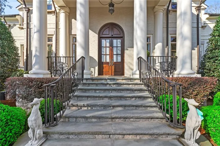 View of exterior entry with covered porch and french doors
