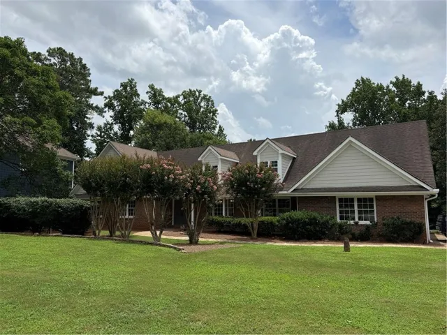 Brick exterior featuring white siding gables and dormers