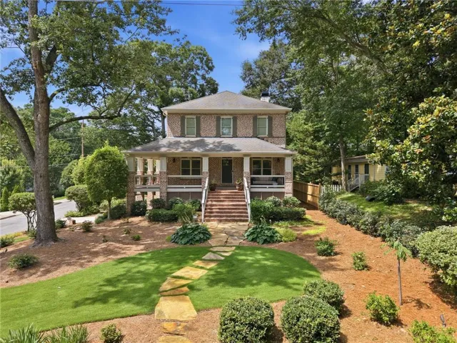 Brick facade residence with a covered front porch and balustrade detailing