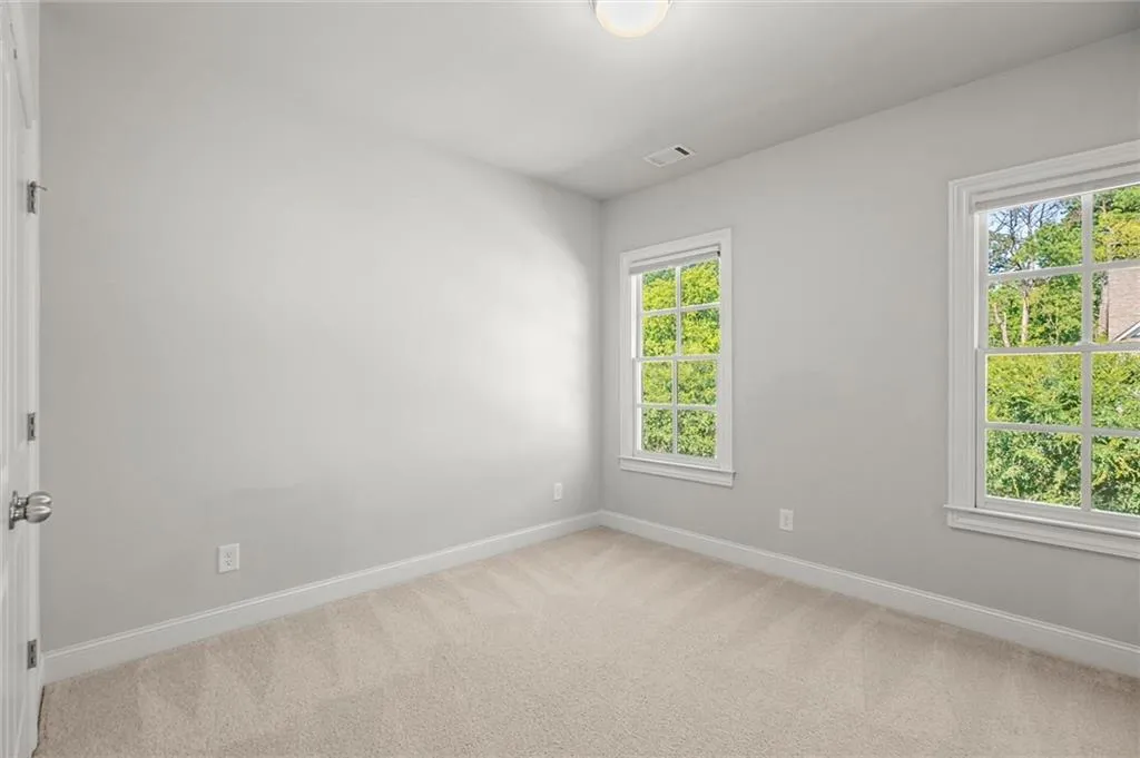 Spare room with light carpet and baseboards