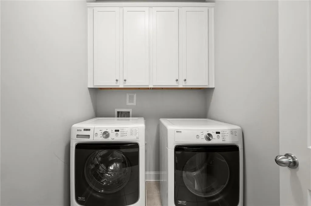 Washroom with washer and dryer and cabinet space