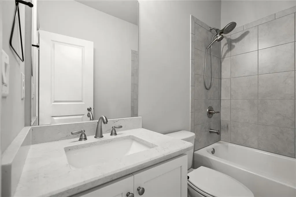 Bathroom featuring vanity and washtub / shower combination