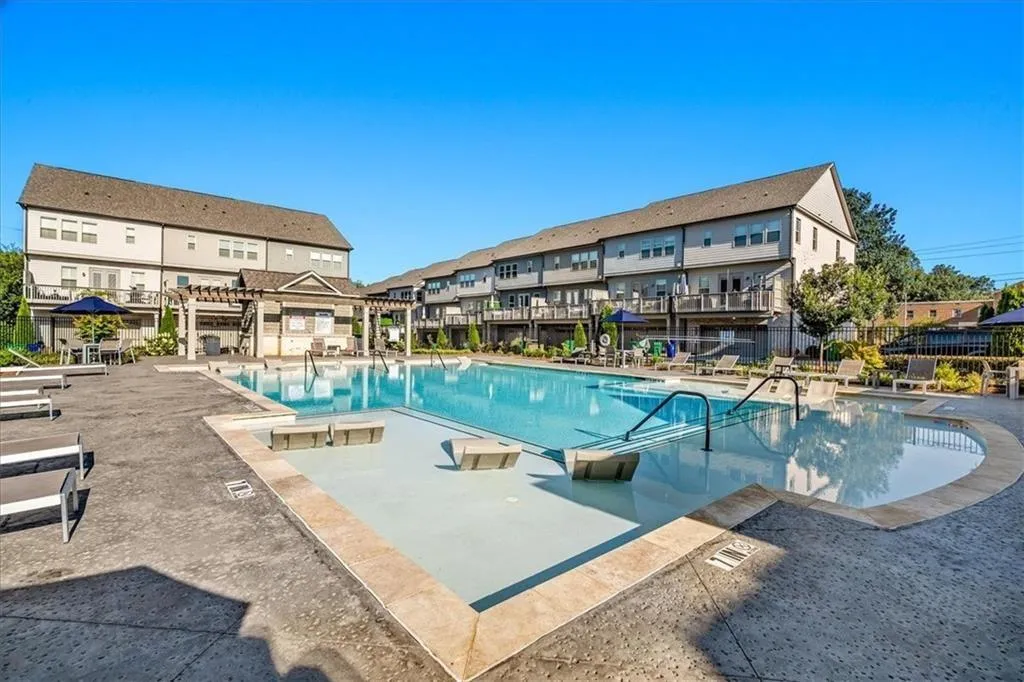 Community pool with a pergola, a patio area, and a residential view