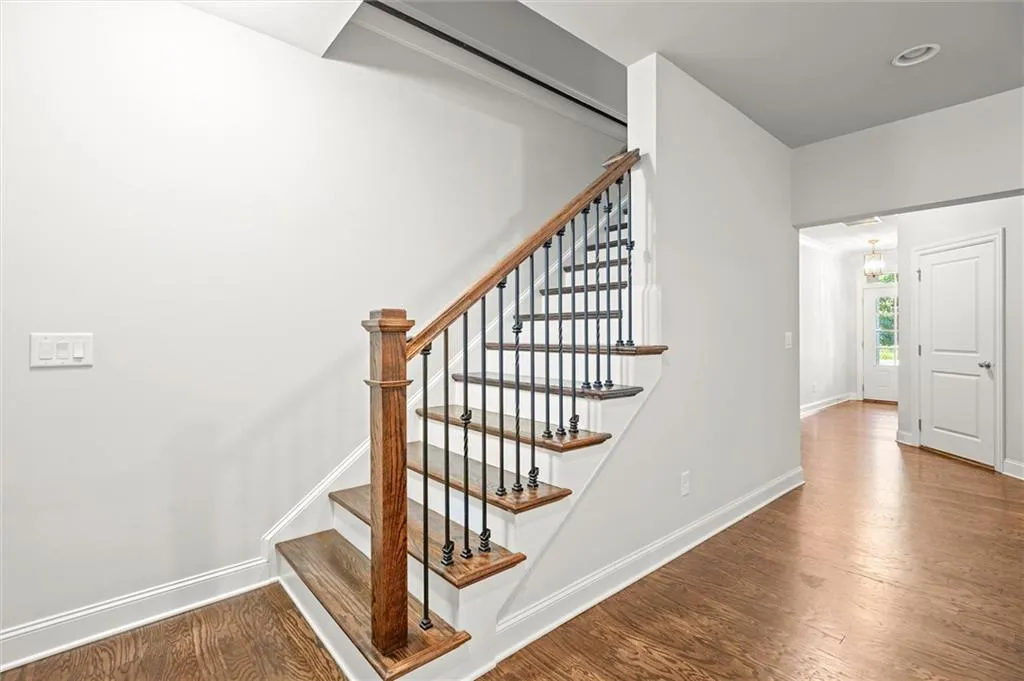 Staircase with wood finished floors and baseboards