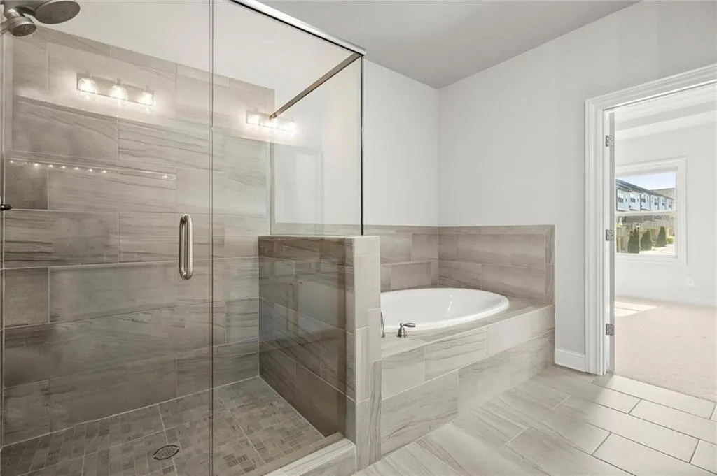 Full bathroom featuring a bath and a shower stall