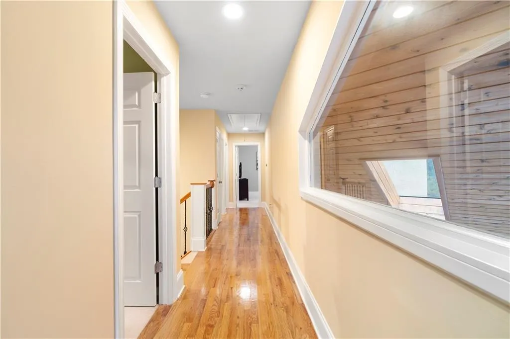 Corridor featuring attic access and light wood-style flooring