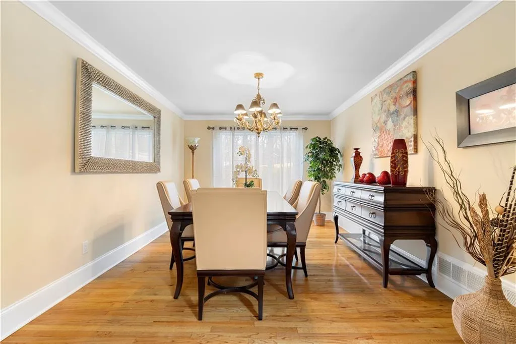 Spacious and natural light formal dining room, hardwood flooring, suspended lighting, and crown molding