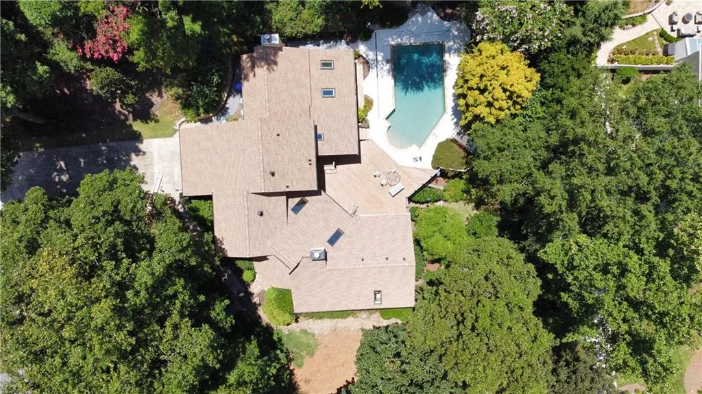 Aerial overview of property's location featuring a pool and mature trees that allow for total privacy