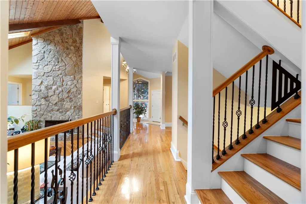 Hall featuring light wood finished floors and vaulted ceiling