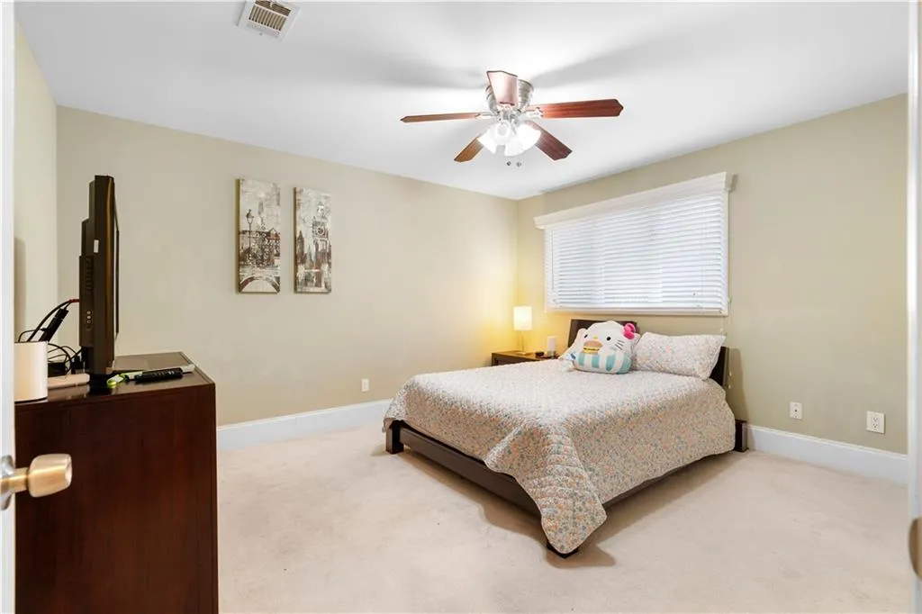 Bedroom featuring light carpet and ceiling fan