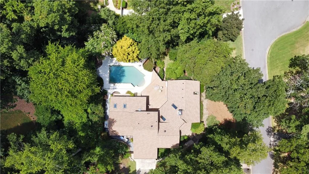 Bird's eye view of a pool area and a tree filled landscape