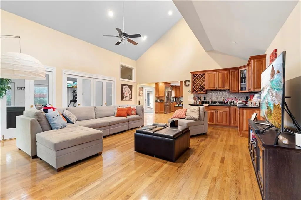 Huge family room with vaulted ceiling, ceiling fan, and bar area