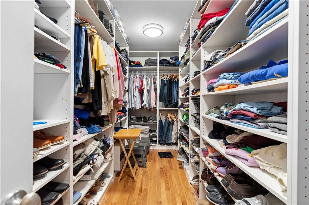 Walk in closet with light wood-style flooring