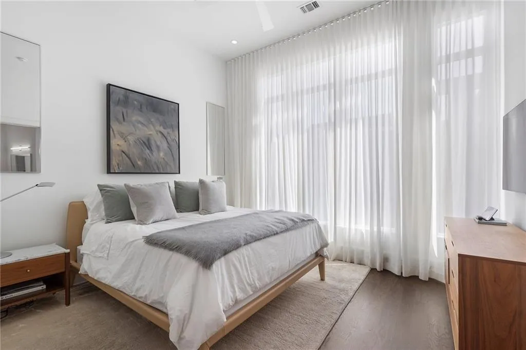 Bedroom with visible vents, multiple windows, and wood finished floors