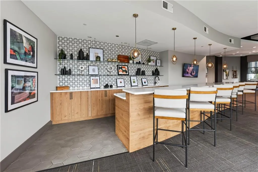 Wood-finish cabinetry, patterned backsplash tiling, and integrated glass shelving create a refined aesthetic