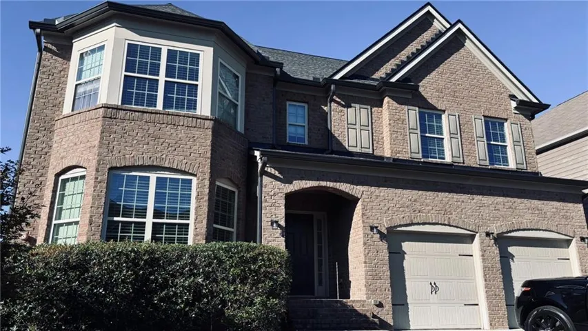 Brick exterior with a prominent bay window, arched entry, two-car garage. New Roof!