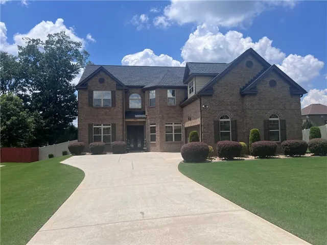 Stately brick exterior featuring multiple gables and a dark shingle roof