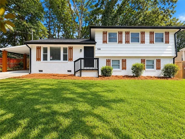 White brick exterior with contrasting wood-tone shutters and a dark roof