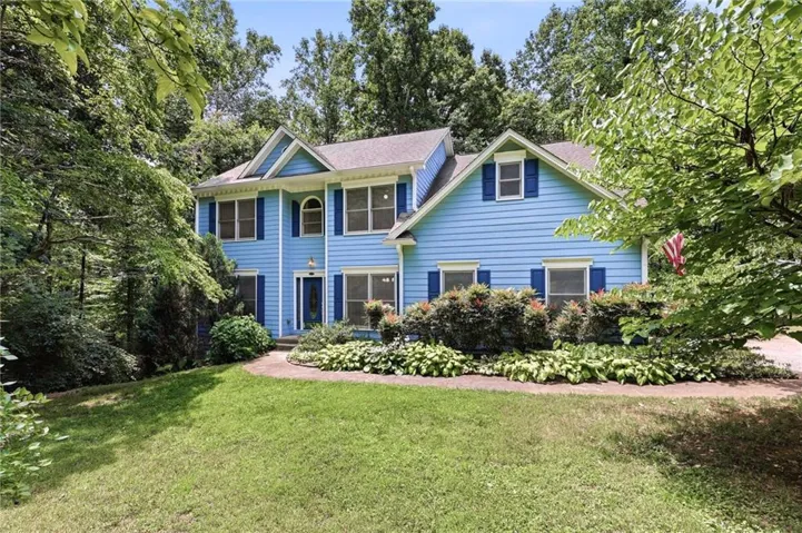 Two-story residence featuring blue siding and dark blue shutters