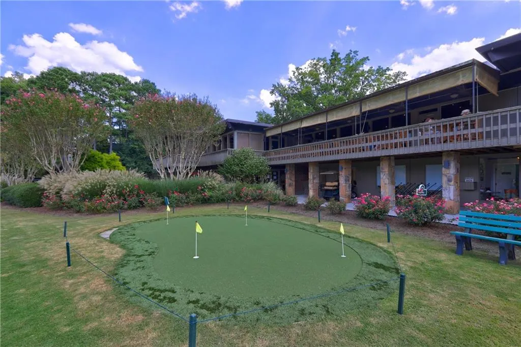 View of community with an area to practice putting and a lawn