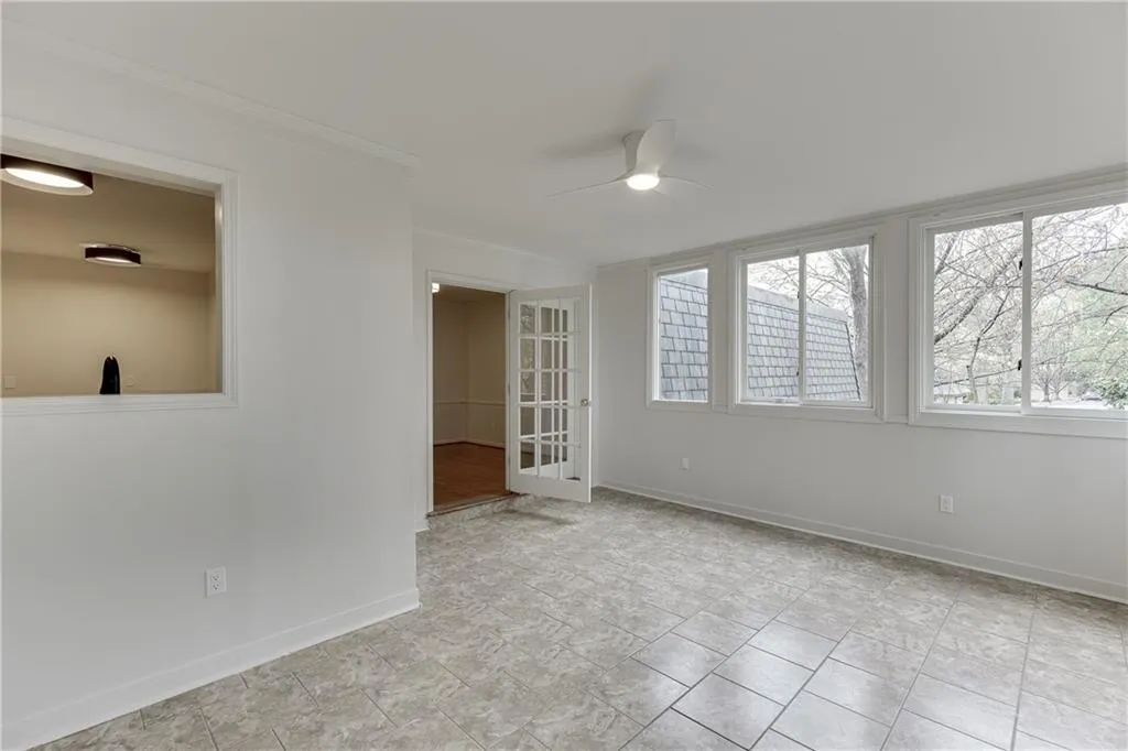 Spare room featuring baseboards, ornamental molding, and a ceiling fan