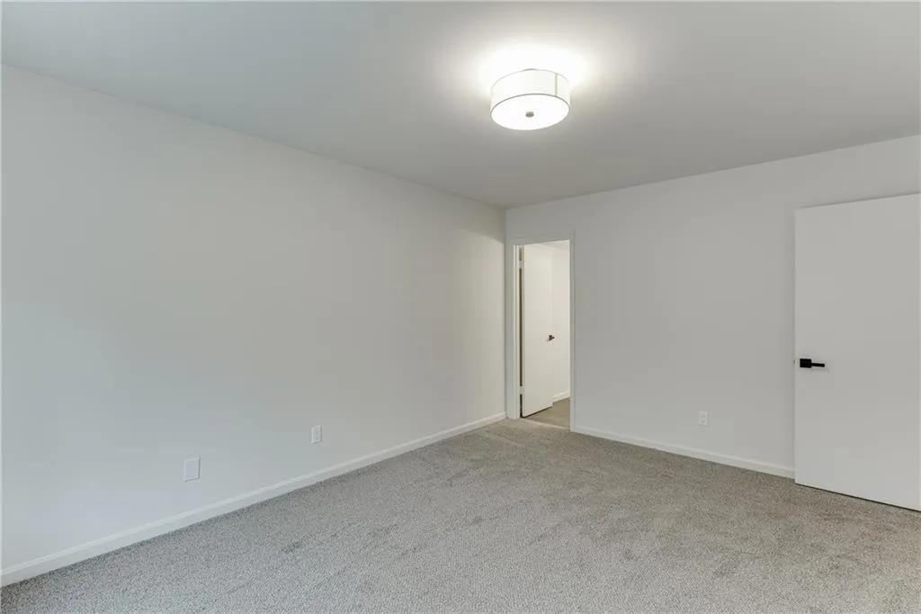 Carpeted spare room with baseboards