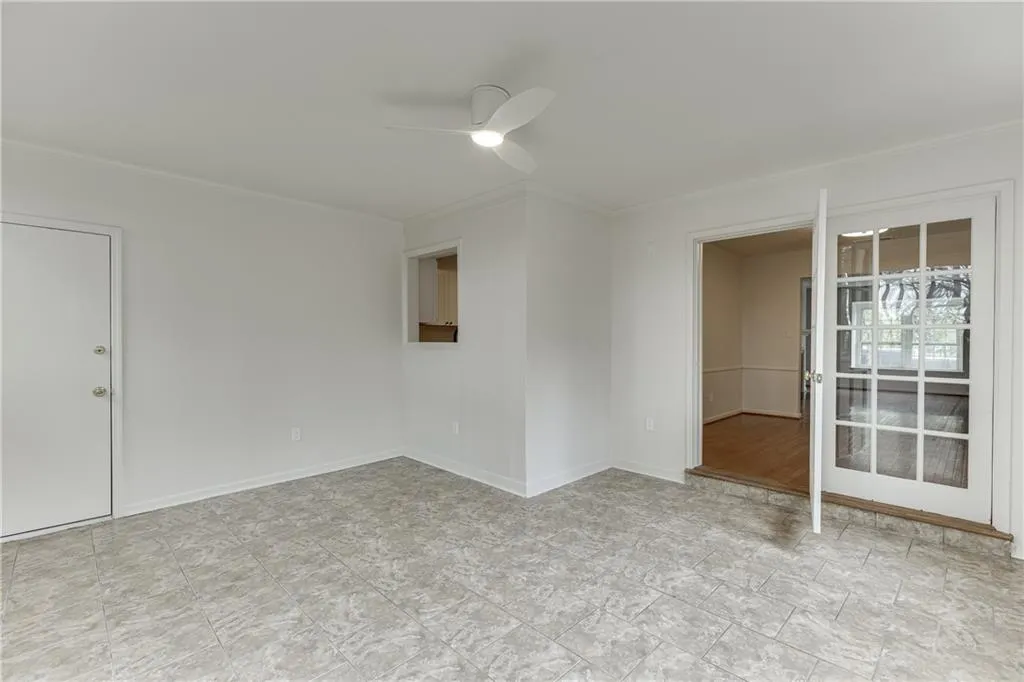 Spare room with baseboards, crown molding, and ceiling fan