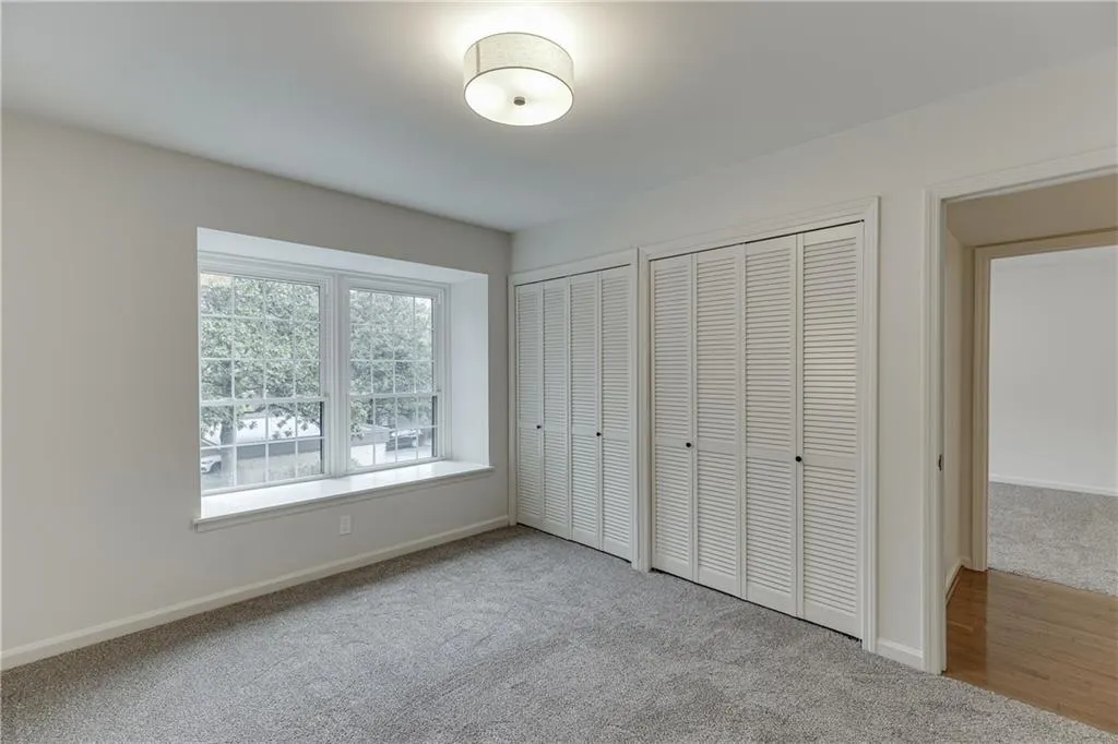 Unfurnished bedroom with two closets, carpet floors, baseboards, and visible vents