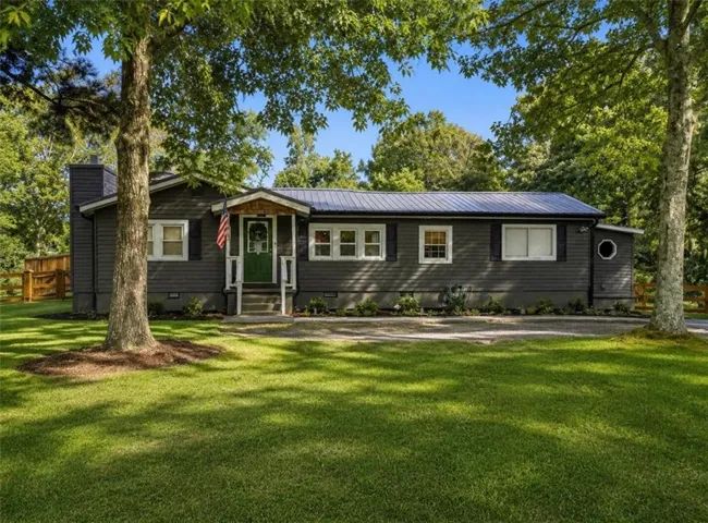 Single-story residence featuring dark gray siding and a dark metal roof