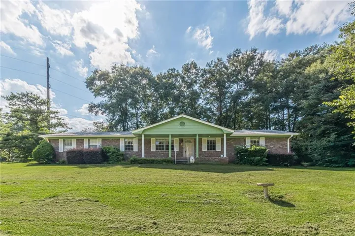 Brick facade with a green accent gable and white porch columns