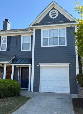 Exterior featuring blue siding, white trim, a single-car garage, and a covered entry